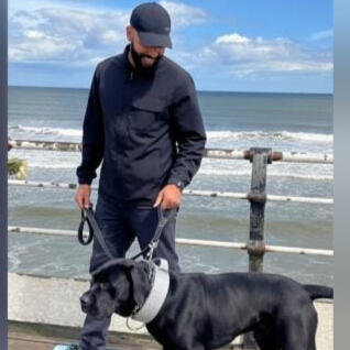 Damian, dog trainer in Middlesbrough, with his dog by the sea